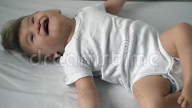 一个身穿白色紧身衣的残疾儿童正试图在床上翻滚